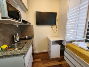a small kitchen with a sink and a tv at Studio ejecutivo in Achumani
