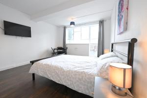 ein Schlafzimmer mit Bett und Flachbildfernseher in der Unterkunft Centrally located flat in Leicester Square in London