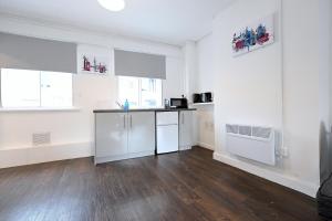 eine Küche mit weißen Wänden und Holzboden in der Unterkunft Centrally located flat in Leicester Square in London + 4 Fotos