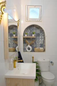 a bathroom with a sink and a toilet and a mirror at Dar Lahlou in Tangier +46 photos