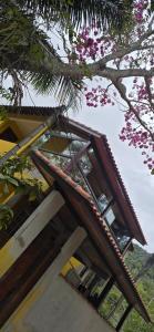 a building with windows and a tree with pink flowers at Aconchego da Lu in Angra dos Reis +5 photos