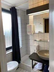 a bathroom with a sink and a toilet and a tub at De Post B&B Restaurant in Klimmen +39 photos