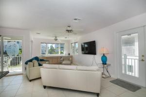 Una sala de estar con un sofá blanco y un televisor. en Great Beach Getaway, Beach & Pool, Sleeps 4, en Bonita Springs