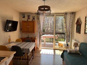 a living room with a table and a sliding glass door at Les Cîmes des Carroz in Les Carroz d'Araches