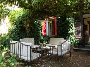 zwei Stühle und ein Tisch auf einer Terrasse in der Unterkunft Villa Il Giardino Di Eugenia by Interhome in Viceno