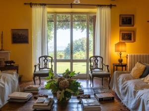 ein Wohnzimmer mit Tisch und Stühlen und einem Fenster in der Unterkunft Villa Il Giardino Di Eugenia by Interhome in Viceno