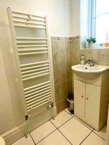 a small bathroom with a sink and a shower at 3-bed cottage in Sway, New Forest (5 min walk from Sway Train Station) in Sway +47 photos