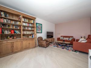 a living room with a couch and chairs and bookcases at Holiday Home Domaine de Maure Vieil by Interhome in La Napoule-Plage