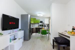 a kitchen and living room with a tv on a wall at Tram Sotto Casa - In DUOMO in un attimo in Milan +17 photos