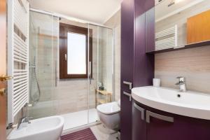 a bathroom with a sink and a toilet and a shower at Tram Sotto Casa - In DUOMO in un attimo in Milan