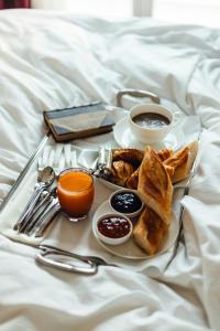 a breakfast tray with toast and coffee on a bed at Palladion Boutique Hotel in Argos