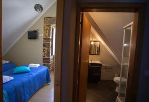 uma casa de banho com uma cama e um lavatrio num quarto em Casas do Terreiro em Seia