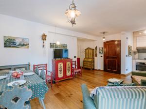 a living room with a table and chairs and a tv at Apartment Luisa by Interhome in Canazei +34 photos
