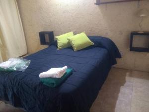 1 cama azul con 2 almohadas y toallas en Departamento amplio en Alta Córdoba con cochera, en Córdoba