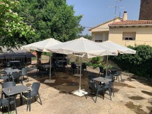a group of tables and chairs under an umbrella at Pension Los Mallos in Riglos