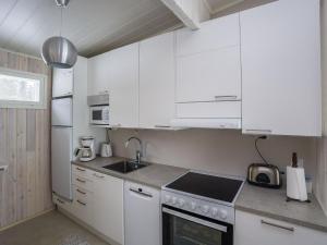 une cuisine avec des armoires blanches et un four à plaques de cuisson dans l'établissement Holiday Home Merikataja by Interhome, à Kemi 18 autres photos