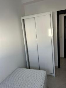 Un dormitorio con una cama y una puerta corrediza de vidrio. en appart neuf foret diplomatique, en Tánger 13 fotos más