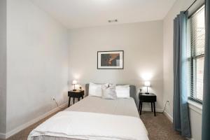 a white bedroom with a bed and two night stands at Music Row w Free Parking in Nashville