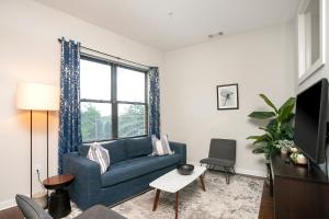 a living room with a blue couch and a window at Music Row w Free Parking in Nashville