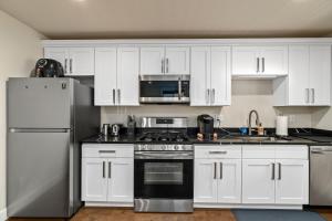 Una cocina con gabinetes blancos y un horno de estufa. en Serene 1 Bdrm, 1 Bath Apartment, en Seattle 10 fotos más