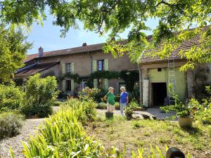 two people standing in front of a house at Gîte La Cour Cachée in Saulx-en-Woëvre