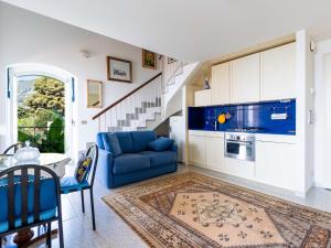 a living room with a blue couch and a staircase at Apartment Loggia sul mare by Interhome in Latte
