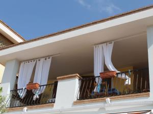 a balcony of a house with white curtains at Apartment Vanda by Interhome in Villasimius