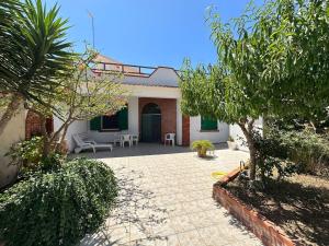 a house with a patio and a courtyard with trees at 6 Minuti Dal Centro-Villetta indipendente-Mazara in Mazara del Vallo