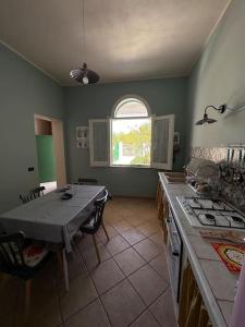a kitchen with a table and a table and a stove at 6 Minuti Dal Centro-Villetta indipendente-Mazara in Mazara del Vallo +5 photos