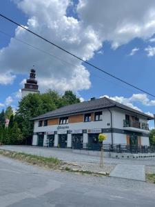 a white building with a clock tower in the background at Apartamenty Olszynka in Górki Wielkie +4 photos