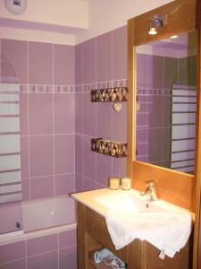 een badkamer met een wastafel, een spiegel en een bad bij Appt Le Hameau Des Rennes 4 étoiles Pieds des pistes Piscine Intérieure Extérieure in Vars