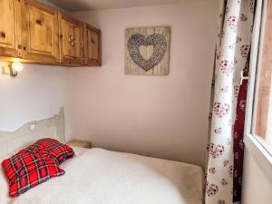 a bedroom with a bed and a heart picture on the wall at Apartment Vanoise-24 by Interhome in Val Thorens