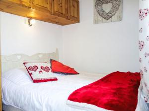 a white bed with a red blanket on it at Apartment Vanoise-24 by Interhome in Val Thorens