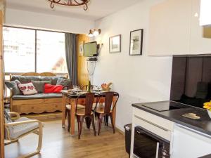 a kitchen and living room with a table and a couch at Apartment Vanoise-24 by Interhome in Val Thorens +17 photos