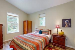 a bedroom with a bed and a dresser and two windows at Balboa Bliss in McKinleyville