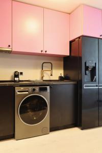 a kitchen with a washing machine and a refrigerator at Cozy Constellations in Poiana Brasov