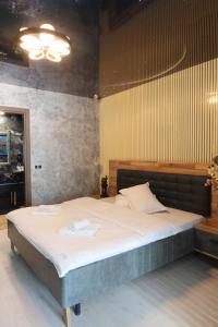 a bedroom with a large bed with two towels on it at Cozy Constellations in Poiana Brasov
