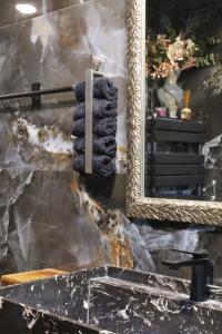 a mirror and a black towel on a rack at Cozy Constellations in Poiana Brasov +27 photos