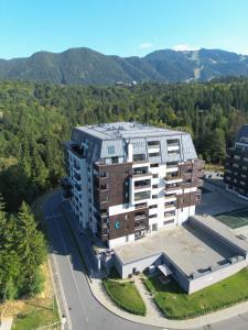 an aerial view of a building with mountains in the background at Cozy Constellations in Poiana Brasov