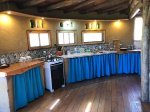 a kitchen with blue curtains on the counters at Malva Rosa Relax La Juanita in José Ignacio +34 photos