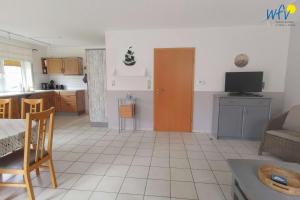 a living room with a table and a kitchen at Huus 24 in Borkum +11 photos
