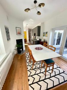 a kitchen and living room with a table and chairs at Flat1Hove- renovated, 2BR, patio, beach, free onsite parking in Hove