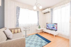 un soggiorno con divano e TV a schermo piatto di Shinjuku 新宿区地下鉄駅まで徒歩4分 a Tokyo
