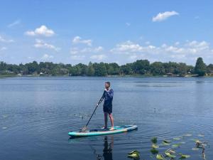 une personne debout sur une planche de paddle sur un lac dans l'établissement Spring Lake King Balcony Suite, à Orlando
