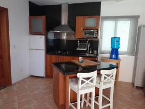 キャバレテにあるAreca Hotel Cabareteのキッチン(テーブル、白い椅子2脚付)