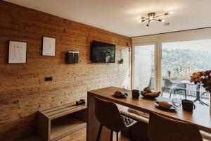 une salle à manger avec une table avec des chaises et une télévision dans l'établissement Harzchalet Emma 3 - mit Sauna - Sankt Andreasberg, à Sankt-Andreasberg