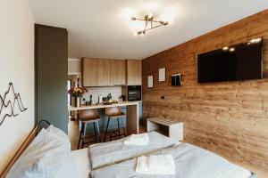 Cet appartement comprend une chambre avec deux lits et une cuisine avec un bar. dans l'établissement Harzchalet Emma 3 - mit Sauna - Sankt Andreasberg, à Sankt-Andreasberg