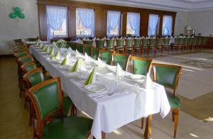 a long table in a room with green chairs at Bukowa Przystań Barlinek in Barlinek