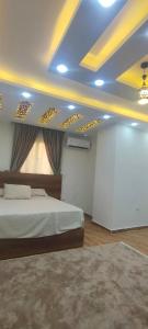 Un dormitorio con una cama y una pared blanca. en فيلا نون, en El Cairo