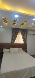 Un dormitorio con una cama blanca y una ventana. en فيلا نون, en El Cairo